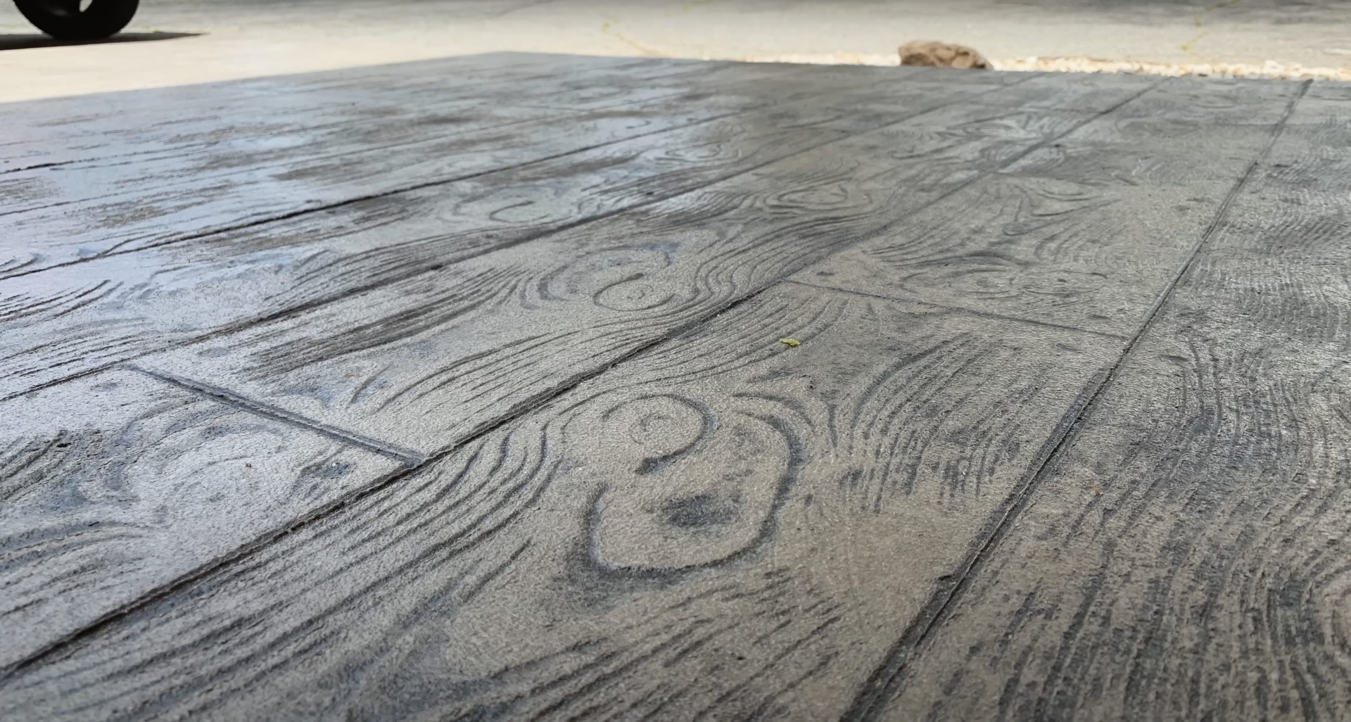 Professional stamped concrete with authentic wood grain finish Stamped concrete surface with realistic wood grain pattern texture