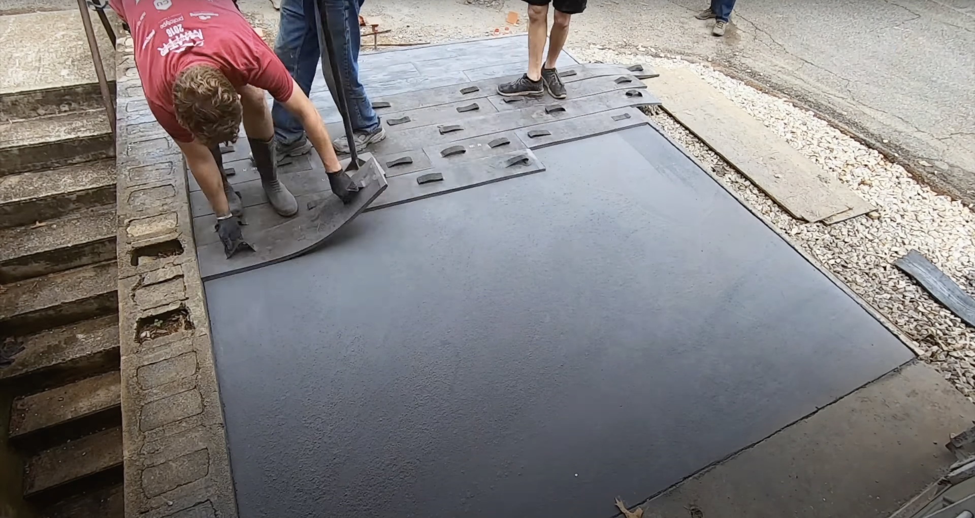 Expert concrete stamping technique for decorative finish Professional concrete stamping work in progress with precise pattern application