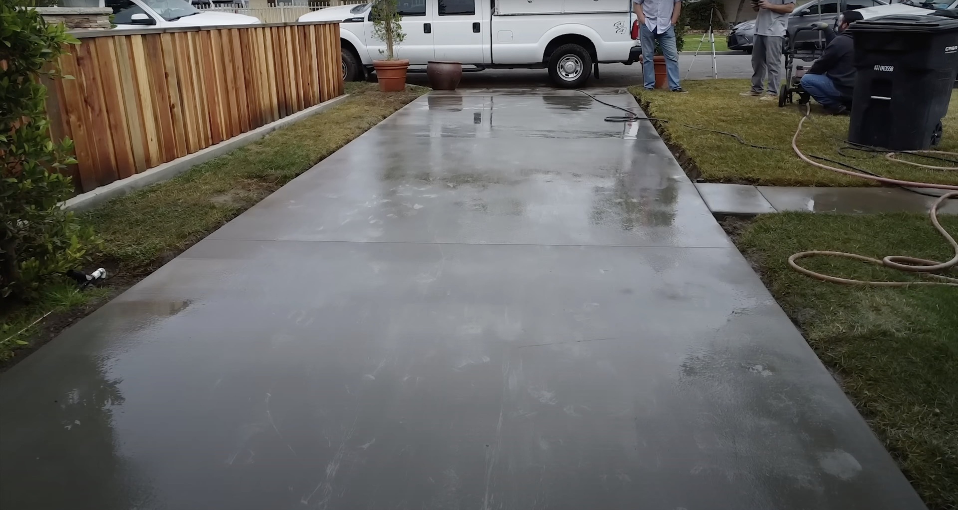Fresh concrete driveway installation with expert finishing Newly poured concrete driveway with smooth professional finish